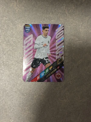 Panini Adrenalyn XL Jesper Lindström kort - Säljer ett Panini Adrenalyn XL Limited Edition samlarkort med Jesper Lindström från Eintracht Frankfurt. Kortet har en glansig lila och silver design med spelarinformation och stats på framsidan. Perfekt för dig som samlar på fotbollskort.