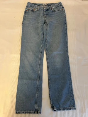 Ljusblå raka jeans från 157 - Säljer ett par ljusblå jeans från 157 med rak passform och klassisk femficksdesign. Jeansen har bälteshällor, knappgylf och är tillverkade i denim. Perfekta för en avslappnad och trendig look.