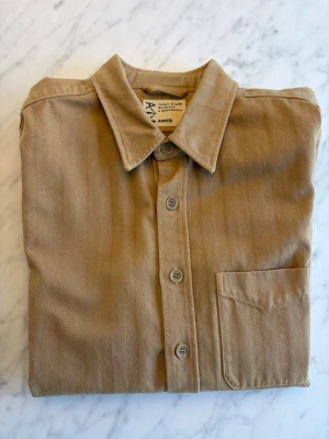 Beige overshirt från Aspesi i bomull - Snygg beige overshirt från Aspesi i bomull. Klassisk krage, bröstficka och knäppning framtill. Perfekt för dig som gillar stilrena och tidlösa plagg. Passar till många olika outfits och är enkel att matcha. Nypris 4200 SEK. Sparsamt använd.