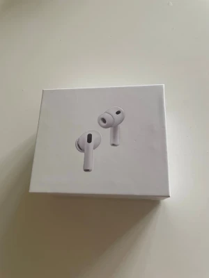 AirPods Pro 3 - Säljer ett par AirPods Pro 3 hörlurar i stilren design. Hörlurarna har silikonproppar och levereras i en kompakt, fyrkantig förpackning. Perfekta för dig som vill ha smidiga och moderna hörlurar till mobilen eller datorn. Airpodsen laddas av ett USB-C uttag och har även Noice cancelling.