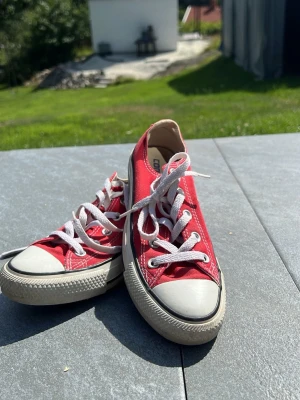 Röda Converse All Star låga sneakers - Klassiska röda Converse All Star sneakers med vit tåhätta och vita snören. Skorna har lågt skaft och är tillverkade i canvas med gummisula. Perfekta för en avslappnad och cool stil.❤️