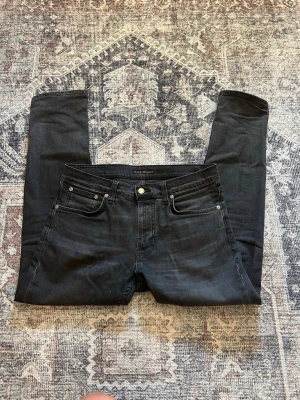 Svarta jeans från Nudie Jeans - Säljer ett par svarta stilrena nudie jeans i mycket gott skick. Storlek 31/30. Pris kan diskuteras!