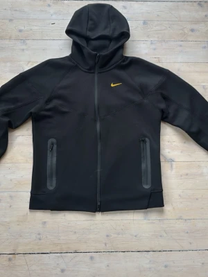 Svart NOCTA hoodie från Nike - Säljer en jävligt fett zip från Nike NOCTA använder den själv inte pågrund av att den är för liten Storlek L men sitter som en Liten M den är alltså helt oanvänd priset är inte hugget i sten och välkomnar även byten mot andra snygga tröjor i storlek L eller en likadan fast i XL 