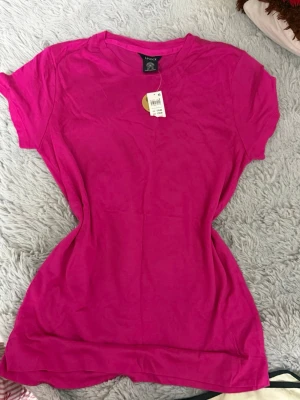 T-shirtpaket Lindex - 3 st - Säljer ett paket med 3 fina T-shirts frän Lindex. Röd - fint använt skick Gul - ny med prislapp Cerise - ny med prislapp Tvà är helt nya med etikett och en är endast provade