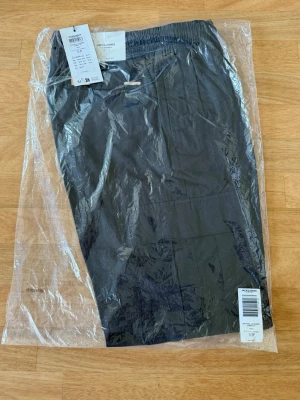 Svarta cargobyxor Jack & Jones  - Snygga svarta cargobyxor från Jack & Jones i modellen JPSTKARL JJSUMMER. Byxorna har elastisk midja och flera praktiska fickor. Perfekta för en avslappnad och trendig stil. Materialet känns lätt och bekvämt.