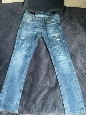 Navy blå Dondup George jeans.  - Säljer ett par navy blå dondup jeans i modellen georges (slim fit). Storlek 31 på jeansen (passar bättre för dig som har typ 30W) Orginal slitningar på jeansen men även ett reparerat hål i skrevet därför det låga priset. 