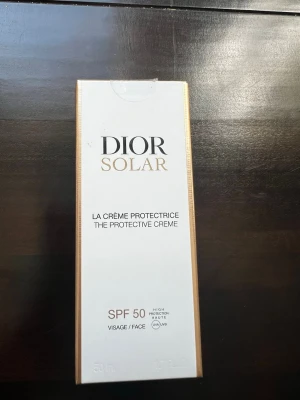 Dior Solar ansiktskräm SPF 50 oöppnad  - Dior Solar La Crème Protectrice är en skyddande ansiktskräm med SPF 50. Kommer i en elegant vit och guld förpackning, 50 ml. Ger hög solskyddsfaktor och är speciellt framtagen för ansiktet. Nu pris 500kr