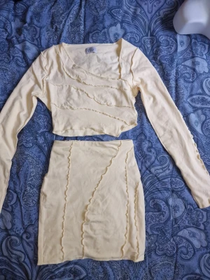 Gult set från Oh Polly med volangdetaljer - Detta set består av en långärmad crop top och en matchande minikjol. Setet har också synliga vågiga sömmar. Priset ör för tröjan som är superfin till höga jeans och långlkol med. Kjolen får man på köpet då det är en liten kaffefläck på 💛 