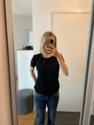 Svart basic t-shirt från Flash - En enkel svart t-shirt från Flash i storlek M med rund hals och korta ärmar. Passformen är normal och materialet är i mjuk bomull. 20 kr!