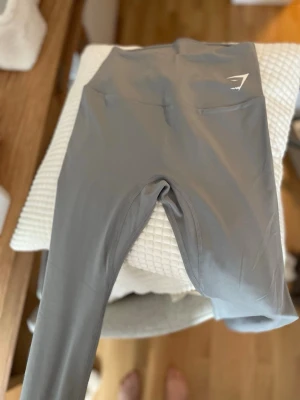 Grå träningsbyxor från Gymshark -  Grå träningsbyxor från Gymshark i storlek S med normal midja och stretchigt mjukt material. Tight passform och raka ben. Aldrig använda. 100 kr!