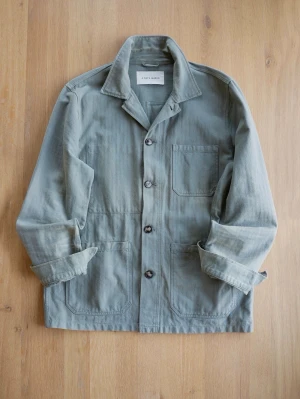 Grön Chore Jacket från A Day's March - Stilren overshirt i dovt grön bomull från A Day's March. Klassisk krage, tre framfickor och knäppning med fyra knappar. Perfekt lager-på-lager-plagg med avslappnad passform och uppvikta ärmar för en casual look.