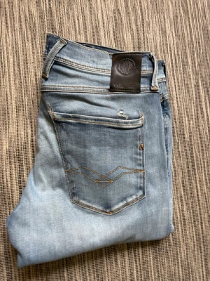 Replay anbass ljusblå - Snygga ljusblå jeans i slim fit-modell med klassisk femficksdesign och slitningar på bakfickan. Jeansen har kontrastsömmar och en patch i läderimitation bak i midjan. Perfekta för en avslappnad och trendig look. Storlek 31 34. Hyperflex, alltså stretchigt och väldigt bekvämt material. Hör av dig vid frågor// kan gå ner i pris vid snabb affär!😃/ Milton