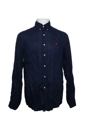 Ralph lauren Mörkblå skjorta - Klassisk mörkblå skjorta med långa ärmar och vita knappar framtill. Skjortan har button-down krage och en liten röd broderad detalj på bröstet. Perfekt till jeans eller chinos för en clean look.