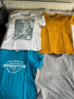Fyra coola t-shirts i olika färger  - Säljer fyra t-shirts: en vit med tryck, en senapsgul med Lylenscott, en turkos med sportigt tryck och en grå från GANT med logga. Alla har rund hals och korta ärmar, perfekta till jeans eller shorts. Och dem säljs i styck 