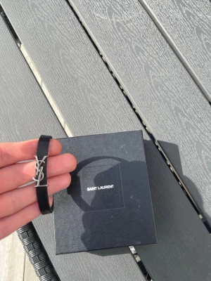 Saint Laurent armband - Sjukt snyggt o tidlöst armband från Yves saint Laurent, har kvitto från NK köpt för 2750kr   Det är iprincip oanvänt. Box, kvitto medkommer