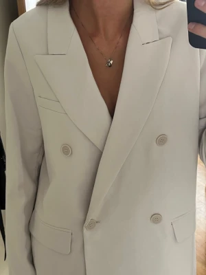 Vit kavaj - Off-white kavaj med dubbelknäppning och breda slag. Strl 36 men lite oversized! ❣️Jättesnygg till jeans eller klänning. Tyvärr bara fått tillfälle att använda den 1-2 gånger. 