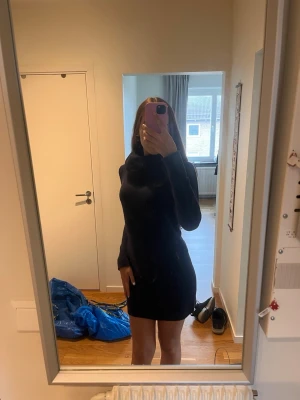 Svart poloklänning med lång ärm - Säljer en svart, tight poloklänning med långa ärmar. Klänningen är kort och har en hög krage som ger en stilren look. Perfekt för dig som gillar minimalistisk och enkel stil. 