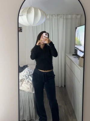 Mörkblå velourbyxor Juicy Couture - Säljer ett par mörkblå mjukisbyxor från Juicy Couture i mjuk velour. Byxorna har dragsko i midjan och raka ben, perfekta för en chill och avslappnad look. Klassisk Juicy Couture-stil som alltid är trendig.