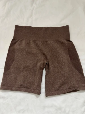 Bruna seamless shorts från NVGTN - Bruna seamless shorts från NVGTN med hög midja och tight passform. Tillverkade i ett mjukt och stretchigt material som passar perfekt för träning. Diskret logga baktill i midjan. Snygga och bekväma för gymmet eller vardagslooken.