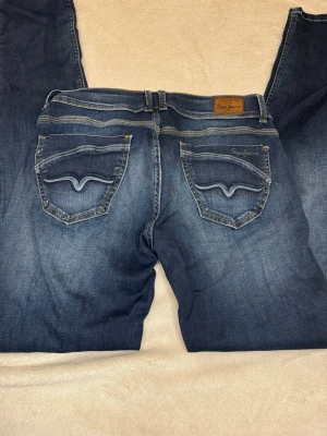 Lågmidjade jeans  - Säljer ett par skit snygga lågmidjade jeans från Pepe jeans london. De är straight i modellen och har finaste detaljerna på fickorna!💕Mått kan skickas privat!