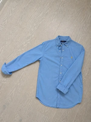 Blå skjorta från Polo Ralph Lauren - Ljusblå Ralph Lauren skjorta, storlek S custom fit. Det finns inga dumma frågor det finas möjlighet vid pris! Knappast använd