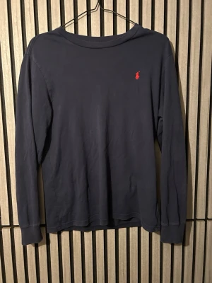 Mörkblå långärmad tröja Polo Ralph Lauren - Snygg mörkblå långärmad tröja från Polo Ralph Lauren knappt använd och har inga hål.
