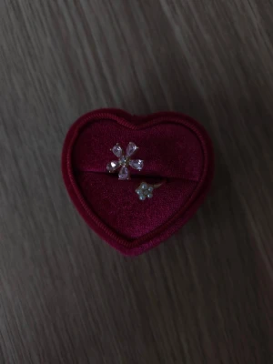 Två blommiga ringar med pärldetaljer - Blomma ring i storlek 19,4mm, guldfärgad.