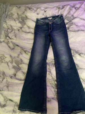 Blå bootcut jeans med slitningar - Hejj!, säljer ett par super snygga jeans från gin Young som har en avklippt design! De är strl 158 och är i super bra skick💕🪽