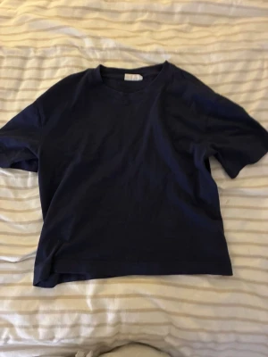 Mörkblå basic t-shirt - En enkel mörkblå t-shirt i klassisk modell med rund hals och korta ärmar. Perfekt till jeans eller shorts och lätt att matcha med andra plagg. Tillverkad i mjuk bomull för skön känsla hela dagen.