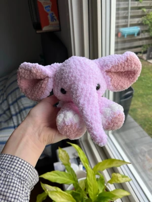 Virkad ljusrosa elefant🐘🩷 - Supersöt virkad elefant av mitt eget mönster ”Ellie the elephant”! Utan rosetter men är istället gjord med superlurvigt garn! Som syns på bilder kan den både sitta och ligga ner. Denna elefant är ljusrosa med vita och rosa detaljer🌸🩷 !OBS, innehåller säkerhetsögon som ej rekommenderas för barn under 3 år! 