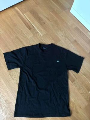 6pm t-shirt  - En klassisk svart t-shirt från 6pm med rund hals och diskret logga på bröstet. Tillverkad i mjuk bomull och har normal passform med korta ärmar. Perfekt basplagg för alla tillfällen.