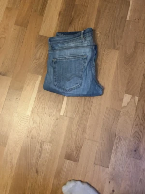 Replay jeans - Ett par ljusblåa jeans ifrån replay i modellen grover. Jeansen har defekter mellan benen (se bild 4) där det är ett hål men kan sys ihop enkelt. Pris kan diskuteras pågrund av defekten.
