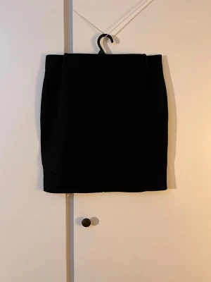 Svart kort tight kjol - Svart kort tight basic kjol från HM som passar till det mesta. Den har en slits i fram. Säljer då den inte längre passar mig. Den är använd en del men den har inga skador. Skriv bara och fråga om det är något!😇