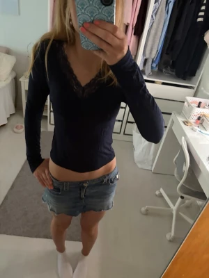 Mörkblå långärmad topp med spets - Snygg mörkblå långärmad topp med v-ringning och spetsdetaljer vid halsen från Gina tricot.
