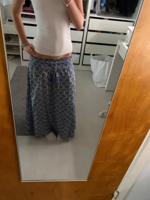 Blå långkjol - Säljer en blå långkjol med vitt och mörkblått mönster från Gina tricot.