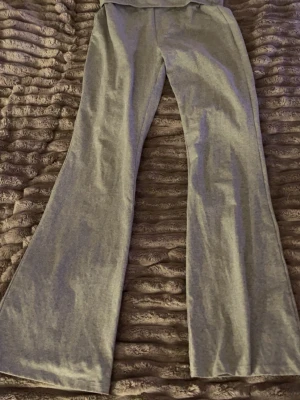 Gråa utsvängda leggings fold over - Snygga grå leggings med utsvängda ben. Tillverkade i ett mjukt och stretchigt material som sitter skönt på kroppen. Perfekta för dig som gillar en trendig och avslappnad stil.