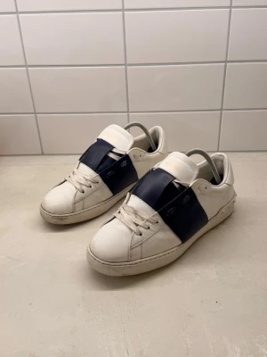 Valentino garavani  - Säljer ett par valentino garavani. Skorna har klassisk låg profil, vita snören och diskreta sömmar. Tillverkade i slätt läder med en stilren och modern look. 