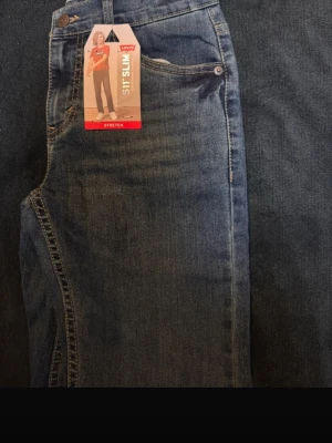 Blå Levi's 515 Slim stretchjeans - Snygga blå Levi's 515 Slim jeans med stretch för extra komfort. Klassisk femficksmodell och raka ben. Jeansen har en tidlös tvätt och passar perfekt till en avslappnad stil. Materialet är mjukt och följsamt denim.