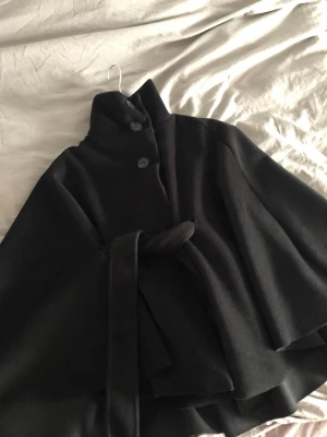 Svart poncho kappa - Aldrig använd. Fin till hösten storlek S passar M