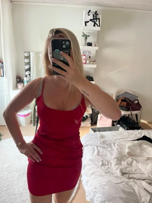 Röd kort klänning från Missguided - Säljer en röd, figurnära kort klänning från Missguided. Klänningen är ärmlös med smala axelband och har en enkel, stilren design. Perfekt för dig som vill ha en snygg och enkel look.