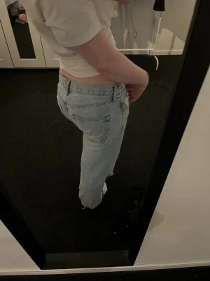 Zara baggy jeans - Säljer ett par ljusblå jeans med raka ben och en stor reva på ena knät. Perfekta för en avslappnad och trendig look. Inga defekter, dock avklippta vid fötterna se bild 5. Förstora i midjan passar mer som en M. Köpta från Vinted