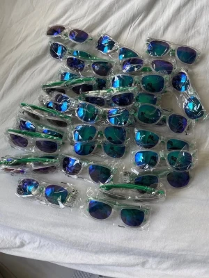 Vita solglasögon med blågröna spegelglas - Säljer flera par solglasögon med vit båge och blågröna spegelglas. Klassisk wayfarer-form som passar till de flesta stilar. Perfekta för soliga dagar och festivaler. Snygg accessoar för dig som vill sticka ut lite extra.