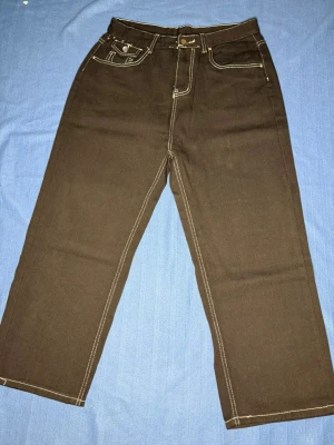 Svart True Religion jeans - Svarta True religion jeans vars storlek jag ej känner till. Köpte de på loppis så jag antar att d ha blivit använda ett tag. Byxan är i sig ganska stor. Skulle säga att den passar någon i stl L.