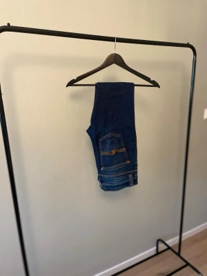Mörkblåa Nudie Jeans 👖  - Snygga mörkblå Nudie-jeans i fint begagnat skick. Klassisk passform som passar till det mesta. Inga större anmärkningar – redo för en ny ägare. 📏 Storlek: 30/32 📦 Skick: Bra begagnat skick 💬 Hör gärna av dig vid frågor eller om du vill ha fler bilder!