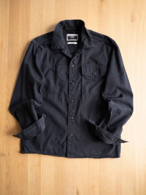 Svart overshirt från Jack & Jones - Svart overshirt från Jack & Jones Core med klassisk krage, två bröstfickor med knappar och knäppning framtill. Tillverkad i bomull och har långa ärmar. Enkel och clean design som funkar till många olika stilar.