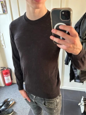 Oscar Jacobsson Brun Merinotröja - Snygg och enkel brun stickad tröja med rund halsringning och långa ärmar. Tröjan är tunn och har ribbade muddar vid ärmslut och nederkant. Perfekt för lager-på-lager och passar till det mesta i garderoben. Hör av dig vid frågor!