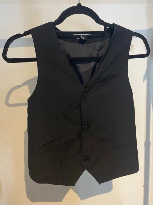 Svart kostym väst - En svart kostym väst från H&M young, storlek 152.