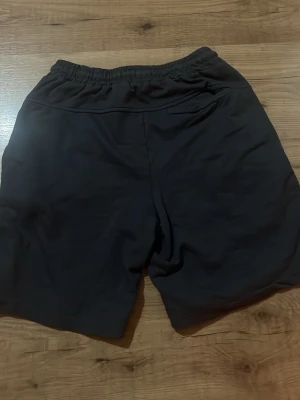 Svarta shorts med resårmidja - Svarta shorts med elastisk midja och snörning. Klassisk och enkel design med två sidofickor. Perfekta för sommaren och avslappnade dagar. Materialet känns mjukt och bekvämt mot huden. Stoleken ser ni på bilden men är size 11-12 och cm 152