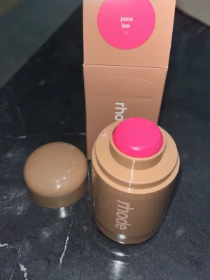 Rhode rouge stick Juice Box - Krämrouge i stickformat från Rhode i färgen Juice Box, en klar och poppig rosa nyans. Förpackningen är beige och kompakt med rundad form, perfekt att ta med i väskan. Enkel att applicera direkt på kinderna för en fräsch look.