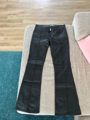 Svarta utsvängda jeans - Snygga svarta jeans/skinn bootcut byxor. Storlek 38/short. Nypris 799kr.